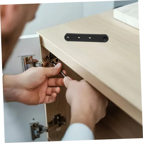 HIAKDOFT stainless steel concealed cabinet hinges installed on a wooden cabinet door; hands tightening with screwdriver.