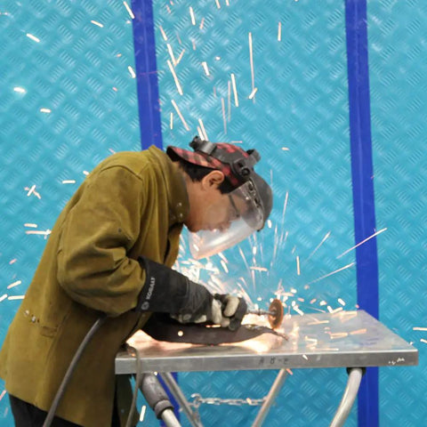 Worker welding with sparks flying, background uses Aqua Shield Surface Protector 10 Mil 36 Inch By 100 Foot Heavy Duty Protective Film.