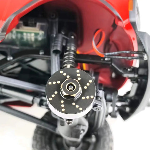 Close-up of Brass Wheel Weights Set 4 Pack 13g Each For 1 24 Scale RC Crawler on Axial SCX24 Model chassis, showing 7mm hub