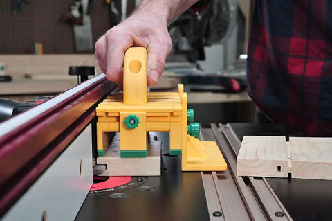 GRR RIPPER GR 100 3D Adjustable Table Saw Pushblock in use on table saw, bright yellow, guiding wood for precise cut.