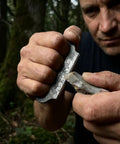 Person using Flint And Steel Fire Starter Kit with Hand Forged Carbon Steel Striker and English Flint Stone in forest