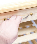 Close-up of hand using drawer pull with Top Shelf Brass Decorative Screws 24 Pack 15Mm on wooden furniture.