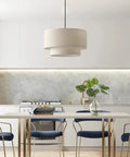 Two Tier Drum Pendant Light With Adjustable Hanging Wire above a modern kitchen table, featuring off white linen shade and black frame.