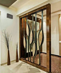 Modern interior design with metal and glass partition, bronze accents, and decorative wall details.