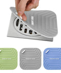 Hand lifting silicone shower drain cover from a round drain, three colors in view, Snag This Three Pack Durable Silicone Shower Drain Cover And Tub Stopper To Cut The Funky Smell And Keep Those Pesky Critters Off Any Bathroom Or Kitchen Floor.