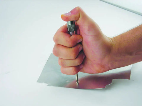 Heavy Duty Automatic Center Punch With Adjustable Stroke And Slick Stainless Steel Body in use, marking metal for drilling.
