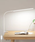 Space Saving Clip On Desk Lamp With Clamp USB Gooseneck Reading Light illuminating a wooden desk with open book