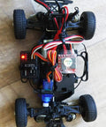 Top view of an RC car chassis with SG90 9g micro servo kit, red/white wiring, blue servo, and ESC.