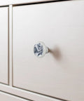 Slick One Point Three Seven Inch Marble Look Cabinet Knobs Four Pack Sharp White Cabochon Glass Drawer Pulls With Silver Silk Texture on light drawer.