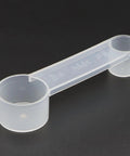 3-Piece Bread Machine Accessories Kit With 300ml Measuring Cup, clear dual-ended plastic measuring spoon on a black background