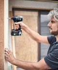 Man using Rock Solid Cordless Impact Driver And Electric Drill Set on wooden framing, showcasing the tool's functionality.