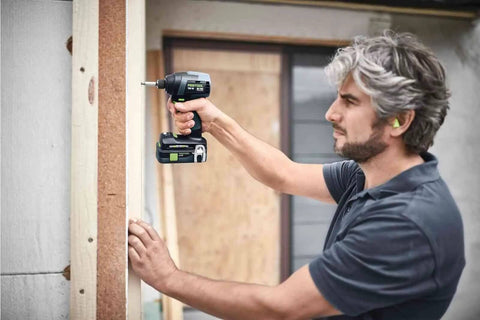 Man using Rock Solid Cordless Impact Driver And Electric Drill Set on wooden framing, showcasing the tool's functionality.