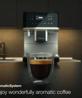 Sleek Fully Automatic Coffee And Espresso Machine With Silent Steel Grinding Chamber For Killer Cup Creations and Rich Silky Milk Foam For Serious Home Baristas displaying espresso in a clear glass cup.