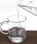 Pouring water into 2 Pack 16 Oz Caffeine Beaker Mug Set, Borosilicate Glass Chemistry Themed Coffee Mugs, showing caffeine molecule design.