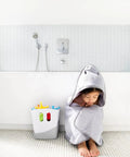 Child in gray towel next to Freestanding Bath Toy Drying Bin With Quick Drain Base, real no mess game changer for keeping kids toys snappy and mold free.