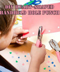 Child using Heart Shaped Paper Punch Handheld Perforator for DIY Crafts on pink paper, creating heart-shaped confetti with soft grip handle.