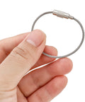 Hand holding Stainless Steel Wire Key Ring Cables 25 Pack, 4.6 Inch Loops For Travel Luggage Tags, Keys, Dog Tags, and Hanging Key Rings