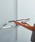 Person installing white sliding basket for closet organization, sturdy pull out wire drawer, adding drawer space in closet system.