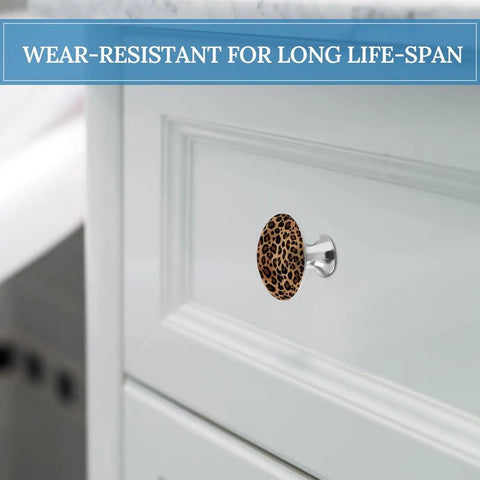 Two Pack Round Stainless Steel Cabinet Knobs With Top Tier Leopard Print Design on white cabinet drawer front