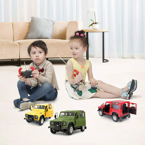 Two children playing with remote controls and a trio of RC cars including Land Rover Defender RC Car One Fourteenth Scale Remote Control Toy Model With Manual Door Open Green Off Road Ready For Kids And Grown Ups Fast Five MPH Top Speed Remote Range Up To Ninety Eight Feet Officially Licensed By Land Rover on the floor.