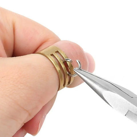 Hand using pliers from 7 Piece Jewelry Pliers Set For Beading And Wire Wrapping on brass rings for jewelry making.