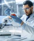 Scientist using 15 Pack 3ml 23 Gauge Plastic Syringe With Measurement in lab for precise handling with tomato and microscope.