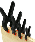 Handy Nylon Spring Clamps Set For DIY Woodworking 2 3 4 6 Inch Clips affixed on a wooden board showcasing secure grip