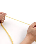 QWORK latex rubber tubing, 1/4 in OD, 3/16 in ID, natural yellow, being stretched by hands