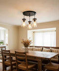 Industrial Mason Jar Pendant Lights for Kitchen Island above wooden dining table in modern farmhouse dining room.