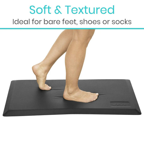 Person stepping on Anti Fatigue Standing Mat For Desk And Kitchen, Ergonomic Cushioned Comfort Pad With Waterproof Surface, 24 by 36 inches.