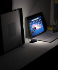 Grab And Go Clip On Book Light With 12 LED USB Rechargeable Battery illuminating a laptop on a dark desk.