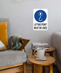 Room with Aluminum Lifting Point Safety Sign 8x12 Inches Durable Industrial Marker on wall above seating area.