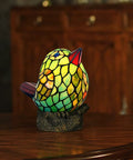 Bird Themed Glass Nightstand Lamp With Blue Green Stained Shade on a wooden table, bird shape, resin base.