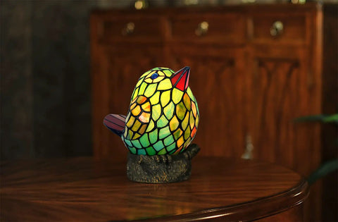 Bird Themed Glass Nightstand Lamp With Blue Green Stained Shade on a wooden table, bird shape, resin base.