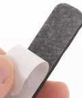 Hand holding a black foam cushion from the Set Of Four Premium Keyboard Soundproof Foam Space Bar Acoustic Cushion.