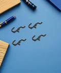 150 Pcs Plastic Pegboard Hooks For Tool Storage And Small Kitchen Supplies, Heavy Duty Repositionable Pegboard Hangers With Easy Assembly, Ideal For Retail Displays And Garage Organization, Studio Gear Black plastic pegboard hooks on blue surface