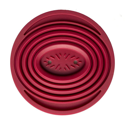 Top view of a red collapsible pour over coffee dripper for camping, showing the foldable silicone design and drainage holes.
