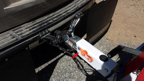 White boat trailer surge brake actuator with orange lockout lever mounted to hitch