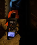 Electrician using Digital Clamp Meter With Auto Ranging TRMS, Measures AC DC Voltage And Current, LoZ Ghost Voltage in panel