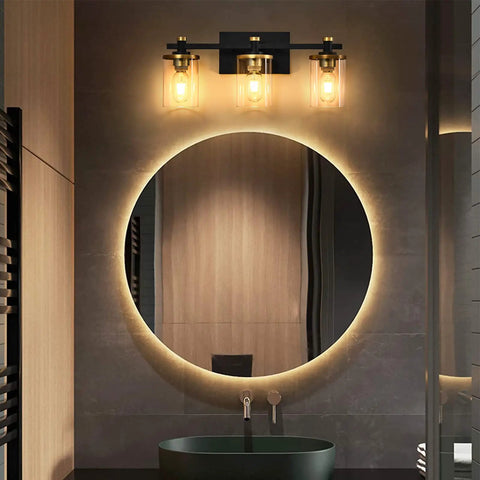 Dope Three Light Vintage Industrial Bathroom Vanity Light Over Mirror In Gold And Black With Clear Glass Shades installed over a round mirror in bathroom setting
