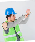Man wearing Tough As Nails Cut Resistant Arm Sleeves With Thumb Hole Grip, using tools in a safety vest and helmet.
