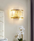 BUNCC Modern Minimalist Metal Wall Sconce, E14 LED Crystal Indoor Wall Light Fixture on the wall near flowers.