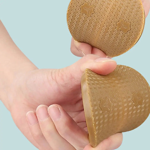 Polyurethane Shoe Heel Repair Pads Half Round Sole Protectors For Sneakers And Athletic Kicks held in hand, textured surface.