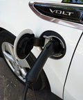 Portable Level 2 EV Charger Up To 32 Amps Adjustable 240V Power connected to a white electric vehicle.