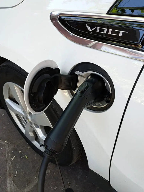 Portable Level 2 EV Charger Up To 32 Amps Adjustable 240V Power connected to a white electric vehicle.