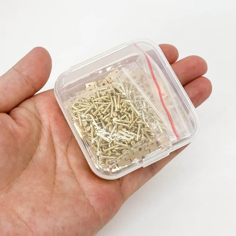 Hand holding a plastic box with Gold Mini Brass Hinges Set For Dollhouse And Tiny Furniture, 100 Pcs 10x8mm 180 Degree Swing Hinges With 400 Mounting Nails