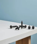 Screws and bolts on a white table surface against a blue background