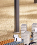Combo Pack Self Adhesive Furniture Sliders For Carpet And Hardwood Floors 32 One Inch Square Gliders visible next to table leg