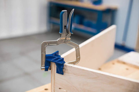 Close-up of a 90 Degree Corner Clamp Set, 2 Pack for Cabinets, Boxes, Drawers and T-Joints, in use on a wooden workpiece.
