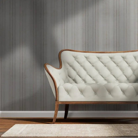 Straight Up Gorgeous Beige Stripe Wallpaper With A Sleek Neutral Silver Metallic Sheen And Cozy Fibrous Texture For That Perfect Modern Lounge Vibe Eco Friendly Pvc Free Wallcovering behind a tufted cream sofa.